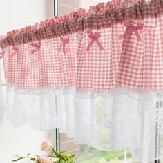 the kitchen window is decorated with red and white checkered curtains, pink bow tie - ups, and lace trim