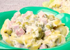 a green bowl filled with pasta and ham