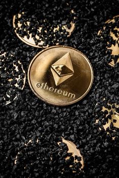 an ethereum coin sitting on top of some black and gold speckles with the word ethereum printed on it