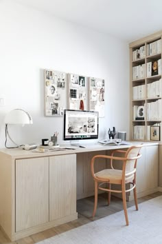 a desk with a computer on top of it in front of a bookshelf