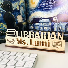 a wooden sign that reads librarian ms lumi next to a keyboard