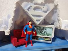 a toy superman figure next to a computer