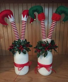 two white vases with red and green christmas decorations