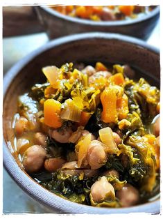 a bowl filled with beans and greens on top of a table