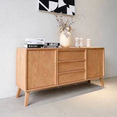 a white vase sitting on top of a wooden dresser