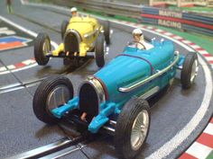 two toy cars on a track with people in them