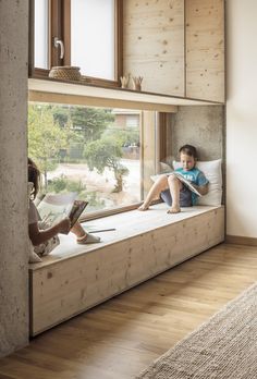 two children are sitting on a window sill