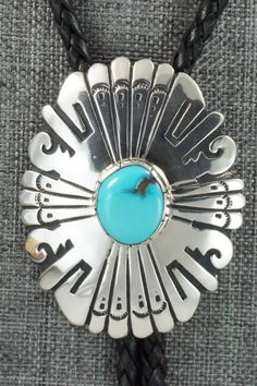 This turquoise and sterling silver bolo tie was made by Navajo silversmith Rosita Singer. The back is signed T&R Singer and stamped sterling.Tie Length: 23"Length: 2 1/4"Width: 1 7/8"Tips:Length: 2 1/8"Width: 1/4"Free shipping on all orders! We ship with USPS and always include tracking. All orders ship within a day of payment.Returns are accepted up to 30 days after you receive your order. Just send us a message. Our shop offers cash back or store credit. The item must be returned in new condit Adjustable Southwestern Silver Turquoise Necklace, Southwestern Sterling Silver Bolo Tie As Gift, Western Silver Turquoise Necklace With Concho, Southwestern Style Sterling Silver Bolo Tie, Artisan Silver Lariat Bolo Tie, Sterling Silver Lariat Bolo Tie, Sterling Silver Bolo Tie, Southwestern Sterling Silver Bolo Tie, Vintage Adjustable Turquoise Bolo Tie