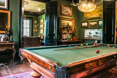 a pool table in a room with pictures on the wall