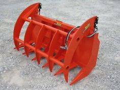 an orange snow plow sitting on top of gravel