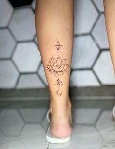 a woman's foot with a lotus tattoo on her left leg and the bottom part of her legs