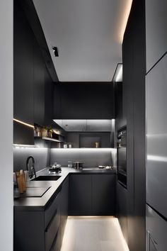 Modern kitchen with dark cabinetry, stainless steel appliances, and under-cabinet lighting. Galley Kitchen Black Appliances, Small Dark Galley Kitchen, Tiny House Galley Kitchen