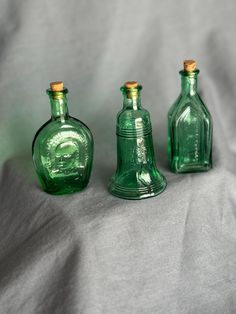 three green glass bottles sitting next to each other