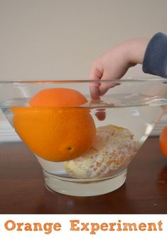 someone is mixing oranges in a glass bowl