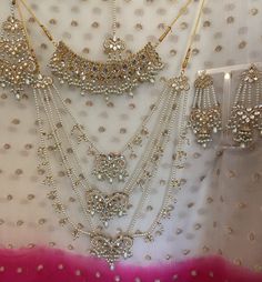 This piece is a showstopper a gold based set with mirror stones & pearl stones and pearl chains. Care instructions: Please keep away from perfume, water and harsh chemicals. To clean please just wipe with a clean dry fibre cloth. No return, no exchange. Silver Kundan Necklace With Pearl Chain For Wedding, Kundan Sets With Stone Work For Wedding, Kundan Bridal Sets With Mirror Work For Wedding, Kundan Bridal Sets With Mirror Work, Bollywood Style Pearl Sets With Stone Work, White Kundan Bridal Accessories With Stone Work, Wedding Kundan Jewelry Sets With Pearl Chain, Silver Kundan Necklace For Wedding Bollywood Style, Kundan Jewelry Sets With Pearl Chain For Wedding