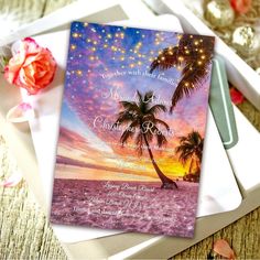 a wedding card with a palm tree on the beach and lights in the sky above it