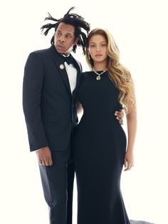 a man and woman in formal wear posing for the camera