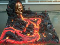 this is an image of a fake volcano with lava and fire in the ground as well as a skull on top