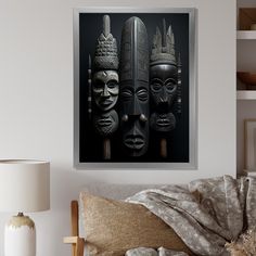 three african masks are hanging on the wall