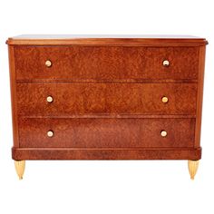 a wooden dresser with three drawers and brass handles on the bottom, against a white background