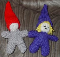 two crocheted dolls are sitting next to each other