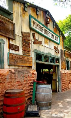 an old building with wooden barrels and signs on the front door that say mine's offering beer