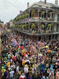 a large group of people standing in front of a building with lots of decorations on it