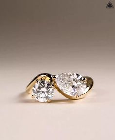 two diamond engagement rings sitting on top of each other