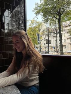 a woman sitting at a table in front of a window