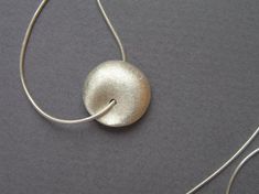 Delicate silver necklace for yourself or as a gift, with a unique bead. Both sides of the bead look the same, it's diameter is about 1.6 cm - 0.6 inch, with a grainy textured matte finish.The chain is 40 cm/16 inch long. Please contact me if you like to have a longer chain.I also have this necklace in 14k gold, with a smaller bead, here:https://www.etsy.com/listing/74255864For another version of this necklace, click here:https://www.etsy.com/listing/79578221To get back to my shop, click here:htt Delicate Silver Necklace, Silver Necklace Pendant, Bead Pendant, Sterling Silver Necklace Pendants, Round Pendant, Long Chain, Beaded Pendant, Sterling Silver Necklace, Necklace Pendant