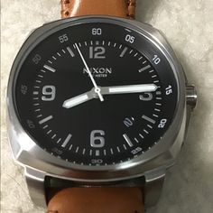 This Is A Beautiful, Near Mint Condition Men's Watch That Goes Well With Blue Denim, Khakis Or Summer Wardrobe. I Suppose You Could Wear It With A Tuxedo, But I Would Recommend White Or Cream Color. The Band Is Light Tan Color, Almost Orange But Not Quite. It's A Rare Nixon Watch That Is No Longer Made And I'm Sure You Will Like It. I Bought This On Poshmark And Then Took It To A Professional Watch Shop And Had A Battery Installed. In No Hurry To Sell Unless Price Can Be Met. Casual Watch Accessories With Analog Display For Everyday Use, Casual Brown Watch Accessories With Subdials, Casual Brown Watch Accessories With Analog Display, Casual Brown Watch With Analog Display, Casual Business Watch With Round Dial, Casual Analog Watches For Business, Casual Analog Business Watches, Casual Leather Watch With Round Dial, Casual Leather Watch Accessories With Analog Display