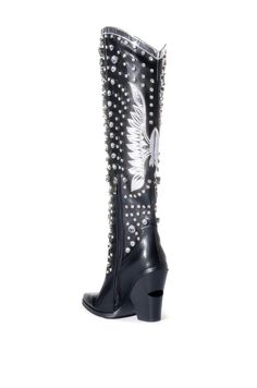 The Upbeat Western Boot In Black is made from a faux leather fabrication and features rhinestone gems in varying sizes, a metallic, rounded collar, a knee-high shaft, Western-inspired patch and stitch detailing, a pointed toe silhouette, a chunky heel, and an inner ankle zipper closure. Feel like a star at any music festival or concert! Faux leather upper Pointed toe Chunky heel 21” shaft height 4.25” heel height Black Western Boots With Rhinestone Rivets, Black Rhinestone Boots For Fall, Black Boots With Rhinestone Rivets For Winter, Black Winter Boots With Rhinestone Rivets, Fitted Leather Boots With Rhinestone Rivets, Leather Heeled Boots With Rhinestones And Round Toe, Embellished Black Heeled Boots For Winter, Embellished Black Heeled Boots For Fall, Black Embellished Heeled Boots For Fall