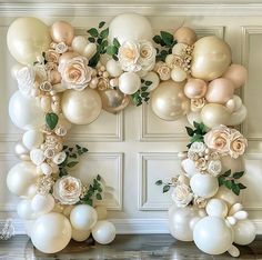 balloons and flowers are arranged in the shape of letter o on a wall with white walls