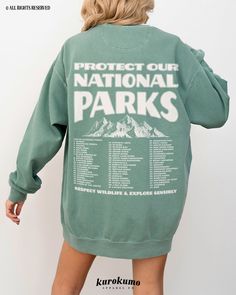 "This Unisex garment-dyed sweatshirt features \"Protect Our National Parks | Respect Wildlife & Explore Sensibly\" with a vintage mountain illustration and a complete list of all 63 National Parks in the U.S. on the back and a badge on the front pocket side. This sweater is perfect for raising awareness about the \"Leave No Trace\" principles when exploring the outdoors as well as being a unique U.S. National Park bucket list! » A B O U T « ‣ This item is made to order using direct-to-garment (D Oversized Long Sleeve Tops For Outdoor, Cotton Sweatshirt For Outdoor Spring Activities, Casual Crew Neck Sweatshirt For Outdoor Activities, Outdoor Crew Neck Tops With Ribbed Cuffs, Spring Cotton Sweatshirt For Outdoor, Spring Outdoor Cotton Sweatshirt, Green Washed Long Sleeve Sweatshirt, Outdoor Letter Print Sweatshirt For Spring, Spring Outdoor Sweatshirt With Letter Print