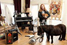 a woman standing in a living room holding a small horse