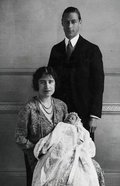 an old photo of a man and woman holding a baby