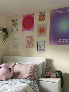 a bedroom with posters on the wall and a pink stuffed animal sitting on the bed