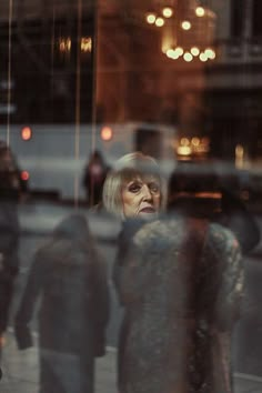 the reflection of people walking in front of a building