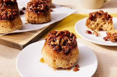 two white plates topped with muffins on top of a table