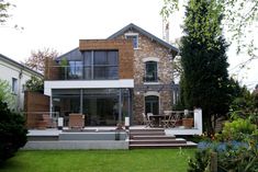 a house that is in the grass with stairs leading up to it's front door