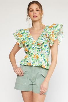 Get ready to turn heads with our Ruffles All Around Top! This playful top features a v-neck and cinched waist, creating a flattering silhouette. With a gorgeous floral print in vibrant greens, blues, orange, and yellow, you'll stand out in any crowd. (Seriously, you'll be the talk of the town.) Don't miss out on this unique piece! True to size. If in between sizes, size up. I’m in the medium here but can also wear the small. Sizes: Small-Large Follow tag instructions for washing and ironing. Vibrant Print V-neck Top For Brunch, Green V-neck Top With Vibrant Print, Green V-neck Top For Brunch, Green V-neck Top With Ruffles, Vibrant Printed Green Tops, Vibrant Green Printed Tops, Green Floral Print Blouse For Brunch, Vibrant V-neck Top For Spring, Vibrant Yellow Floral Print Tops