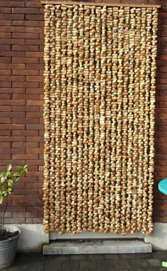 a wall made out of wine corks on the side of a brick building next to a blue chair