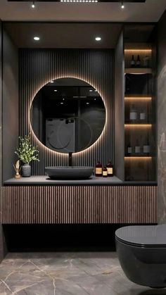 a bathroom with a round mirror above the sink and a black tub in front of it