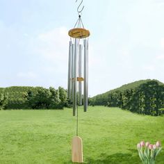 a wind chime in the middle of a grassy field