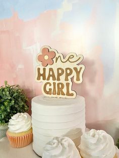 there is a cake and cupcakes on the table with one happy girl sign