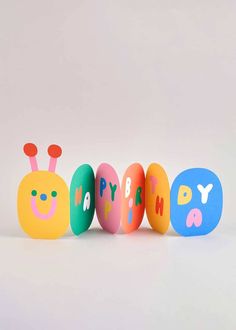 three colorful eggs with the words happy birthday written on them in different colors and shapes