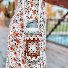 a woman wearing a crochet bag with a cell phone in her pocket,