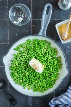 peas and butter in a pan with spoons on the side