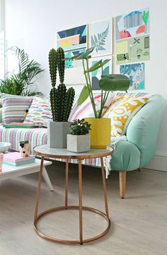 a living room filled with lots of furniture and plants on top of it's tables