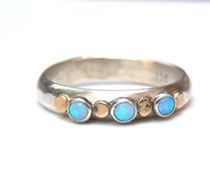 OPAL RING You are looking at a beautiful HAND MADE silver ring with opal stones. The  stones are setting in silver  bezel. There is 4 solid gold dots. It is impressive, powerful and very beautiful ring. This ring can be made to order in any size. Please note your desired size in the message to seller area at checkout. size tiny stone is 3 mm. width band ring: 4mm Come in a  gift box. Fallow me on facebook for newest updates. http://www.facebook.com/pages/Orit-Naar-jewelry/174677569247132?sk=wall Opal Ring Engagement, Opal Mineral, Opal Band Ring, October Gifts, Opal Solitaire Ring, Blue Opal Ring, October Birthstone Rings, Opal Band, Sparkly Things